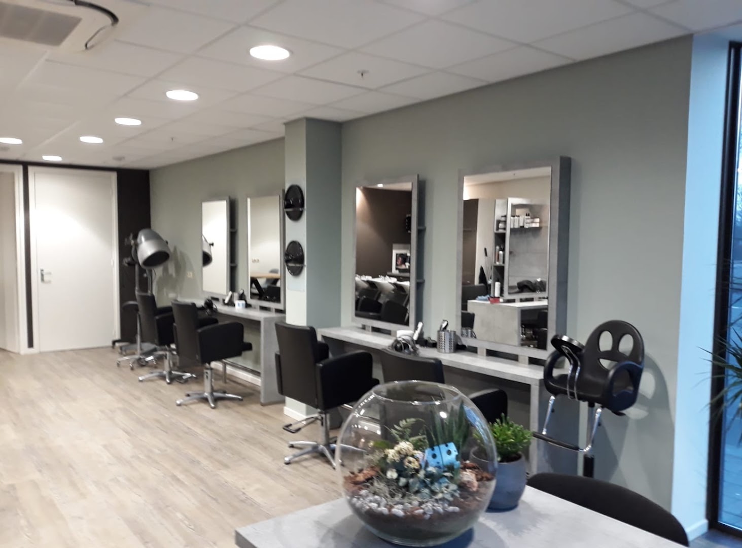 Lichte kapsalon met kappersstoelen en spiegels